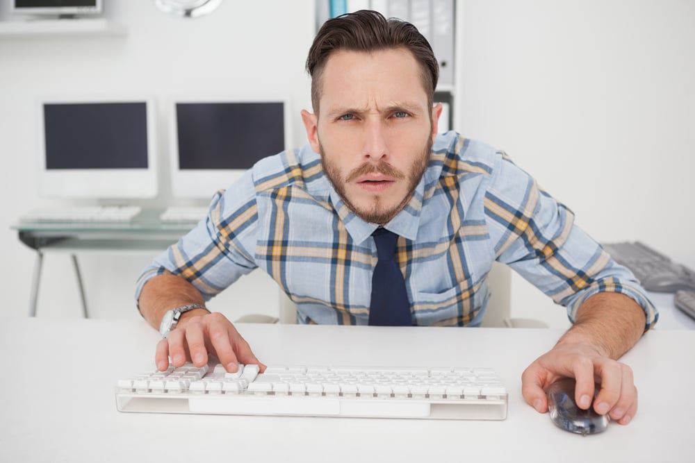 Man sitting at keyboard staring at computer screen